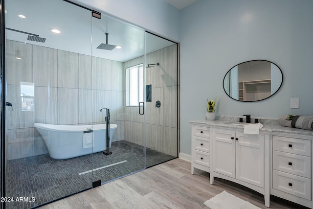 bathroom with separate shower and tub, vanity, and hardwood / wood-style flooring