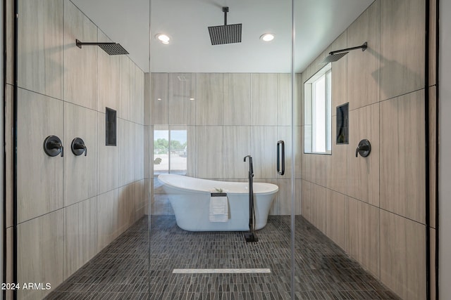 bathroom featuring separate shower and tub, tile patterned flooring, a healthy amount of sunlight, and tile walls