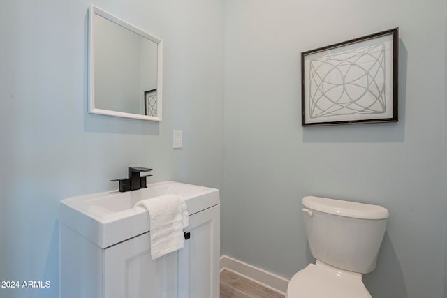 bathroom featuring vanity, hardwood / wood-style flooring, and toilet