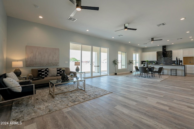 living room with ceiling fan and light wood-type flooring