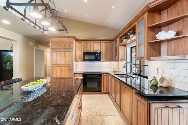 kitchen featuring vaulted ceiling, tasteful backsplash, sink, dark stone countertops, and black appliances