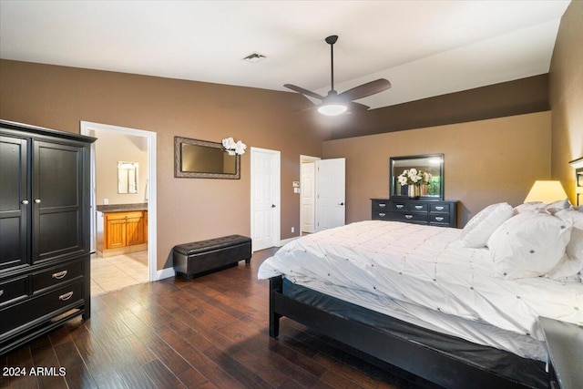 bedroom featuring wood-type flooring, lofted ceiling, ensuite bathroom, and ceiling fan