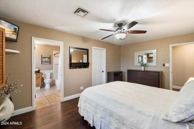 bedroom with dark wood-type flooring, ceiling fan, and connected bathroom