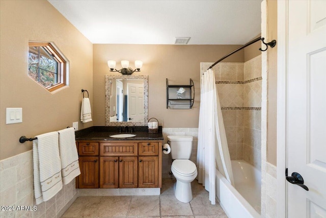 full bathroom featuring tile patterned floors, toilet, tile walls, vanity, and shower / bathtub combination with curtain