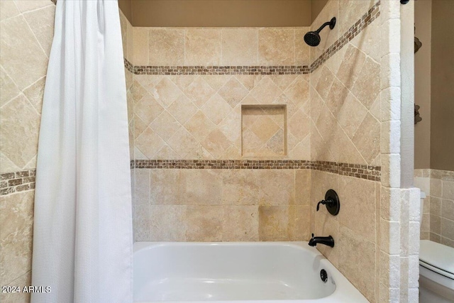 bathroom featuring shower / bathtub combination with curtain and toilet