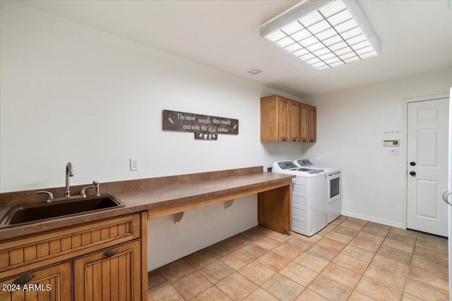 washroom with sink, washing machine and dryer, and cabinets