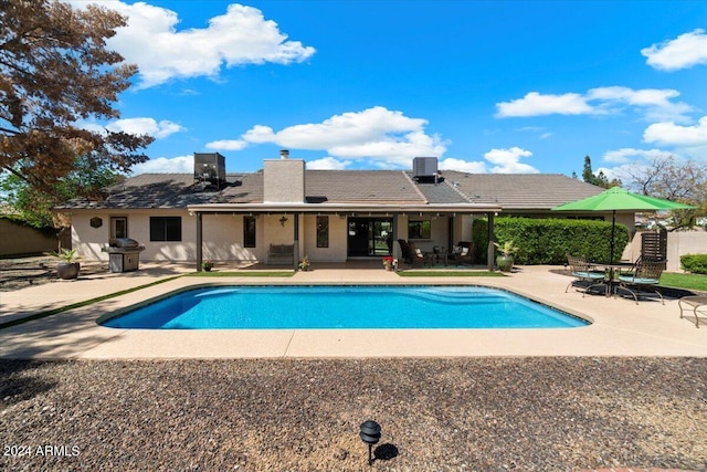 view of pool with area for grilling, central AC unit, and a patio area