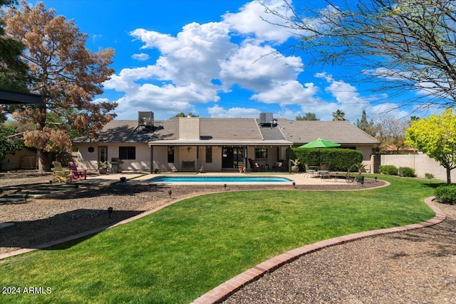 rear view of house with a yard and a patio