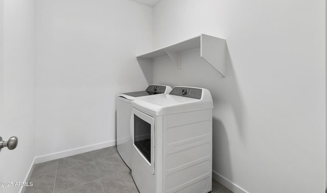 laundry area with separate washer and dryer and light tile patterned floors