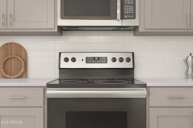 kitchen with tasteful backsplash, light stone countertops, and stainless steel appliances