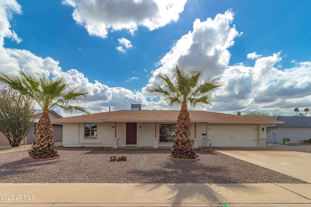 ranch-style home featuring a garage, driveway, and stucco siding