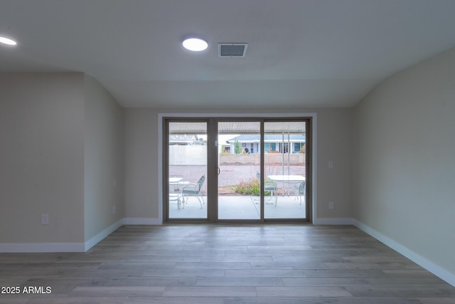 empty room with visible vents, baseboards, and wood finished floors