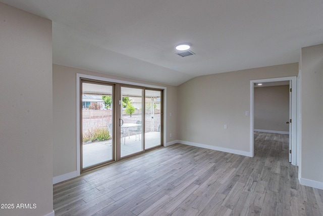 unfurnished room with lofted ceiling, baseboards, visible vents, and light wood finished floors