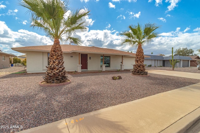 ranch-style home with covered porch, a garage, and stucco siding