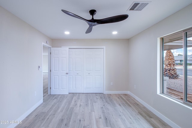 unfurnished bedroom featuring light wood-style flooring, baseboards, visible vents, and a closet