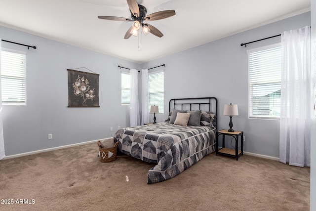 carpeted bedroom featuring multiple windows and ceiling fan