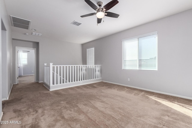 carpeted spare room with ceiling fan