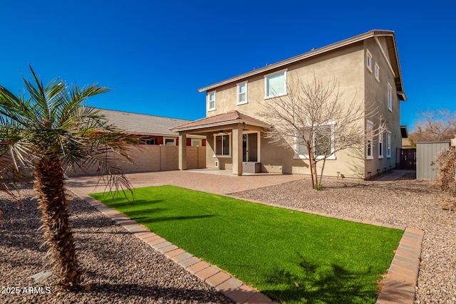 back of house with a yard and a patio