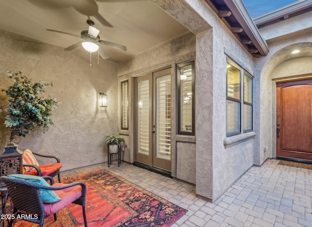 view of exterior entry featuring a patio and ceiling fan