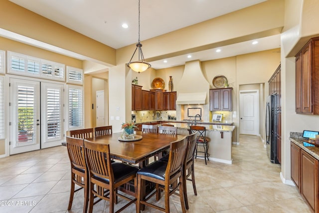 dining area with light tile patterned flooring, sink, french doors, and a high ceiling