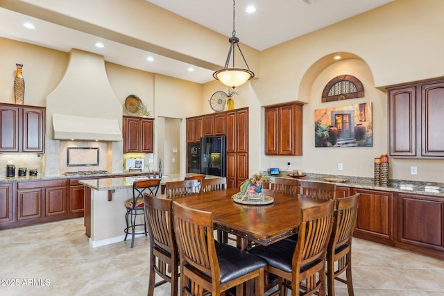 tiled dining area featuring a towering ceiling