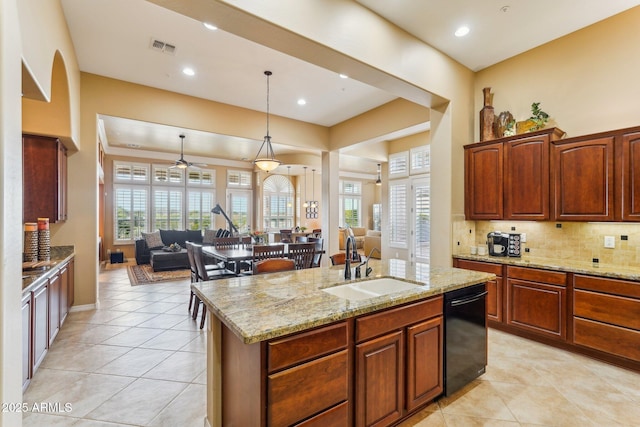 kitchen featuring pendant lighting, sink, dishwasher, a center island with sink, and decorative backsplash