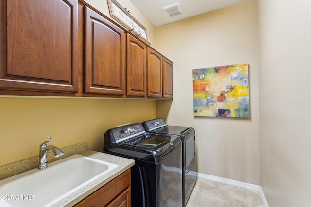 clothes washing area featuring washer and dryer, light tile patterned flooring, sink, and cabinets