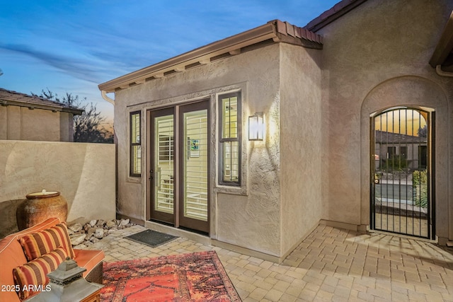 exterior entry at dusk featuring a patio