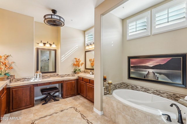 bathroom with vanity, tile patterned flooring, and tiled bath