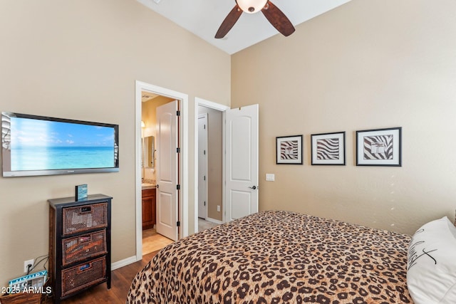 bedroom with ceiling fan, ensuite bath, wood-type flooring, and lofted ceiling