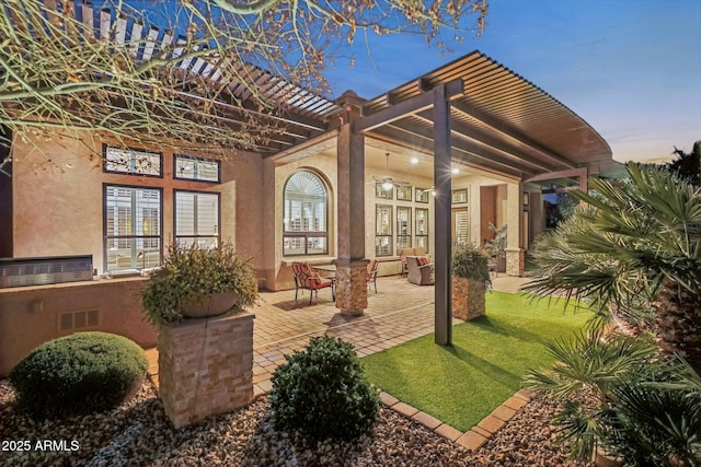 patio terrace at dusk with french doors, a lawn, and a pergola