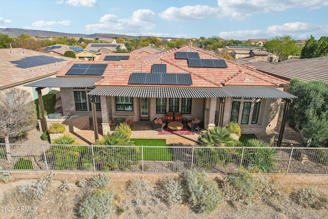 back of house with a patio and solar panels