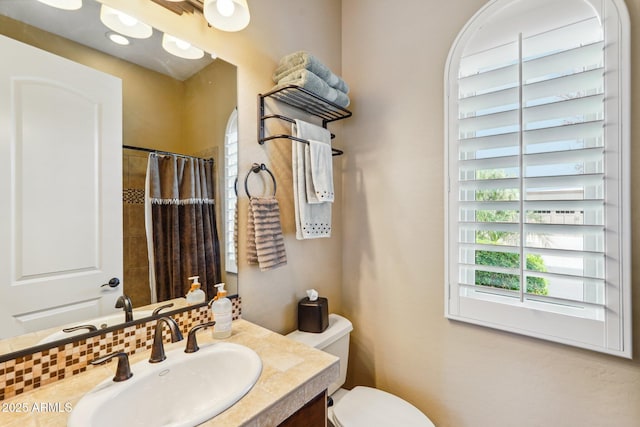 bathroom featuring vanity, a shower with shower curtain, decorative backsplash, and toilet