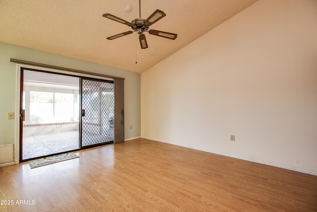 spare room featuring vaulted ceiling, a ceiling fan, baseboards, and light wood finished floors