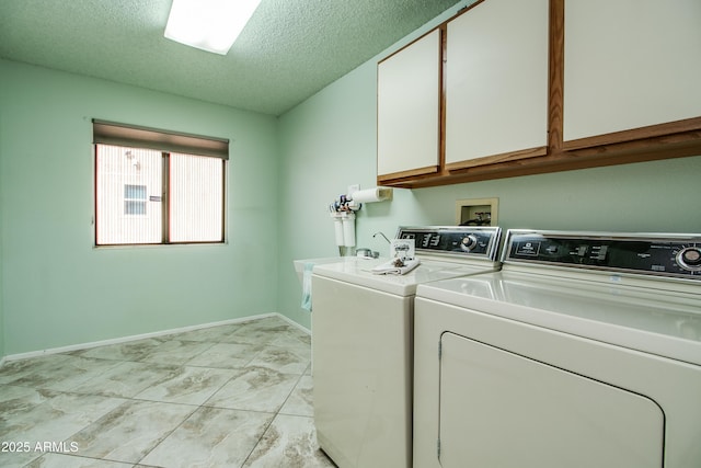 laundry area featuring cabinet space, independent washer and dryer, a textured ceiling, and baseboards