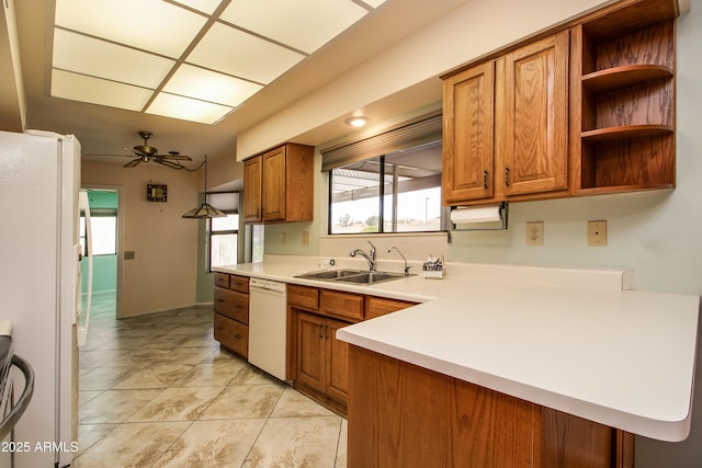 kitchen with ceiling fan, white appliances, brown cabinets, and a sink