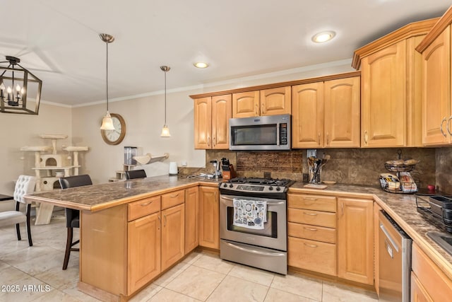 kitchen featuring appliances with stainless steel finishes, decorative backsplash, a kitchen bar, decorative light fixtures, and kitchen peninsula