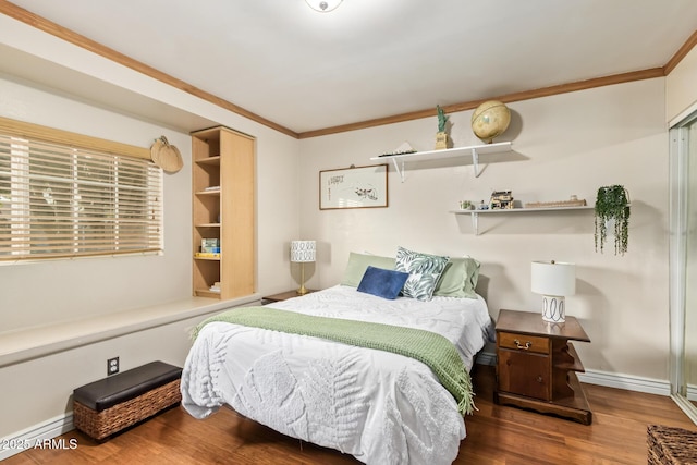 bedroom with baseboard heating, ornamental molding, and hardwood / wood-style floors