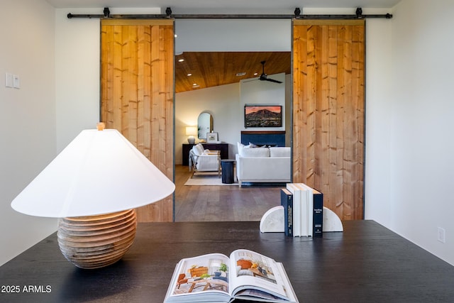 interior space featuring dark hardwood / wood-style flooring, lofted ceiling, and a barn door