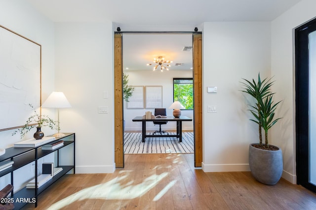 hall with hardwood / wood-style floors and a notable chandelier