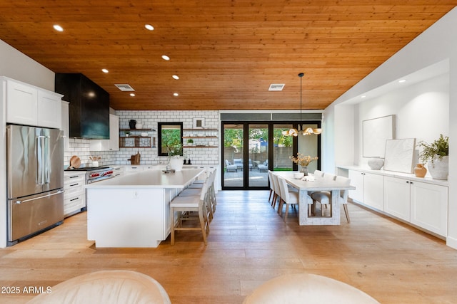 kitchen with high quality appliances, white cabinetry, wooden ceiling, and decorative light fixtures