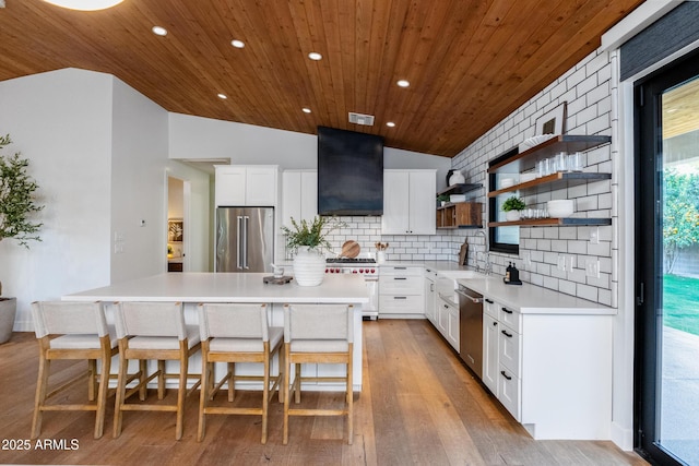 kitchen featuring white cabinets, a kitchen bar, a kitchen island, and premium appliances