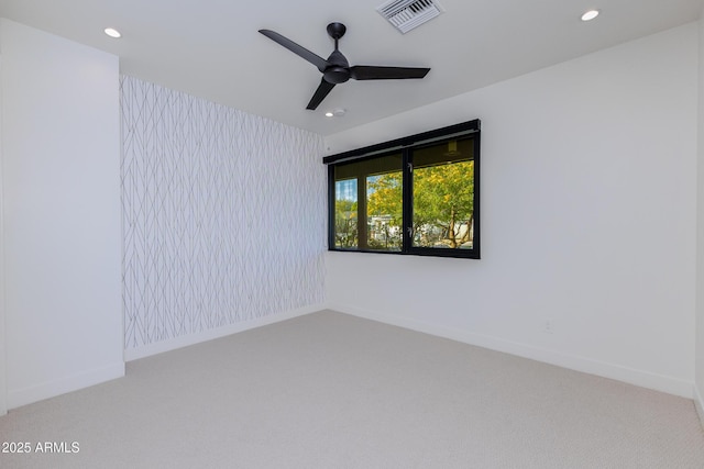 carpeted spare room featuring ceiling fan