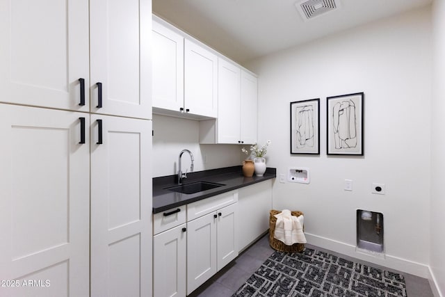 washroom featuring sink, dark tile patterned flooring, cabinets, washer hookup, and electric dryer hookup