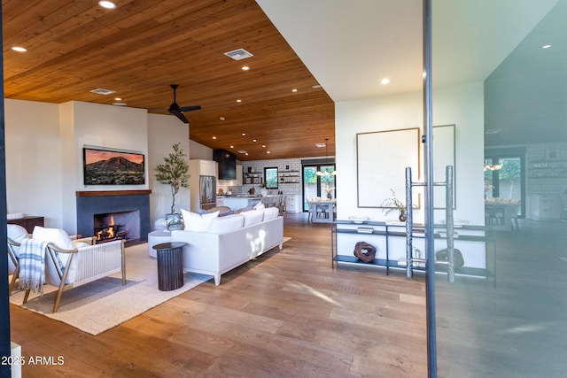 living room with hardwood / wood-style flooring, vaulted ceiling, wooden ceiling, and ceiling fan