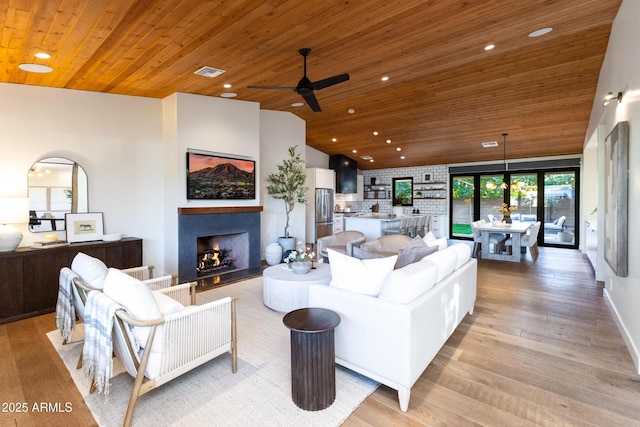 living room featuring vaulted ceiling, wooden ceiling, and light wood-type flooring