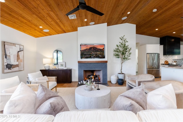 living room featuring wood ceiling, ceiling fan, light hardwood / wood-style floors, and vaulted ceiling