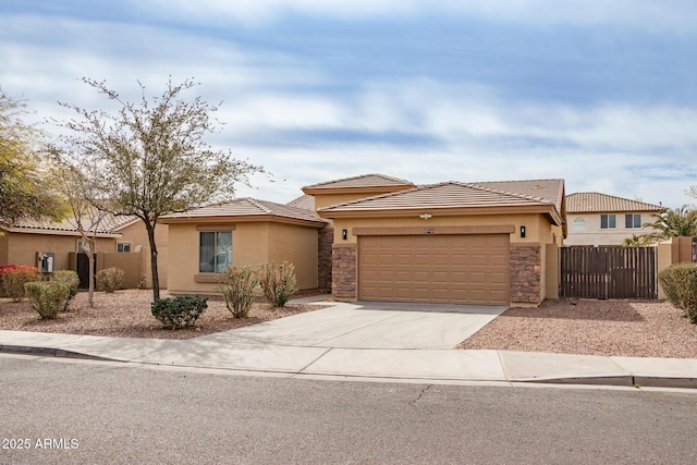 view of front of home featuring a garage, concrete driveway, fence, and stucco siding