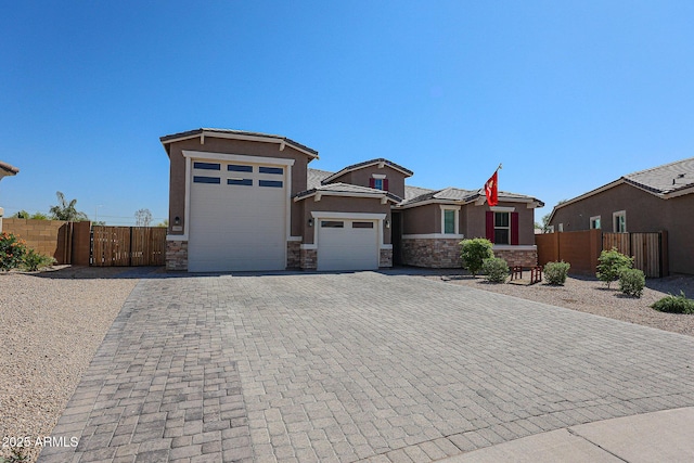 3907 S 75th Dr, Phoenix, AZ 85043 - view of front of property with stone siding, an attached garage, fence, and decorative driveway