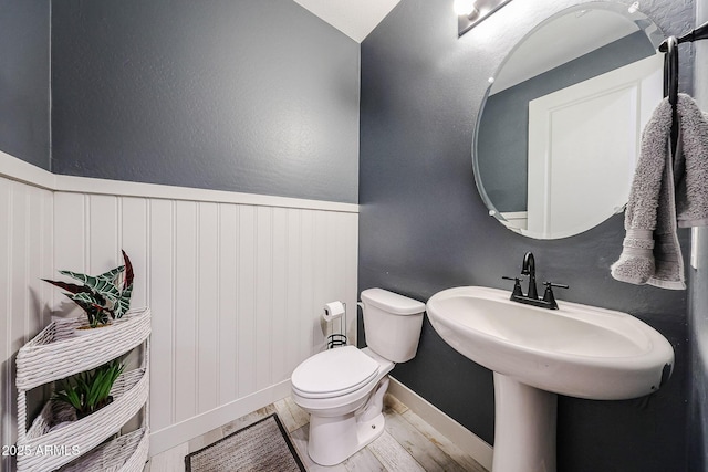 3907 S 75th Dr, Phoenix, AZ 85043 - half bathroom featuring toilet, a wainscoted wall, and wood finished floors